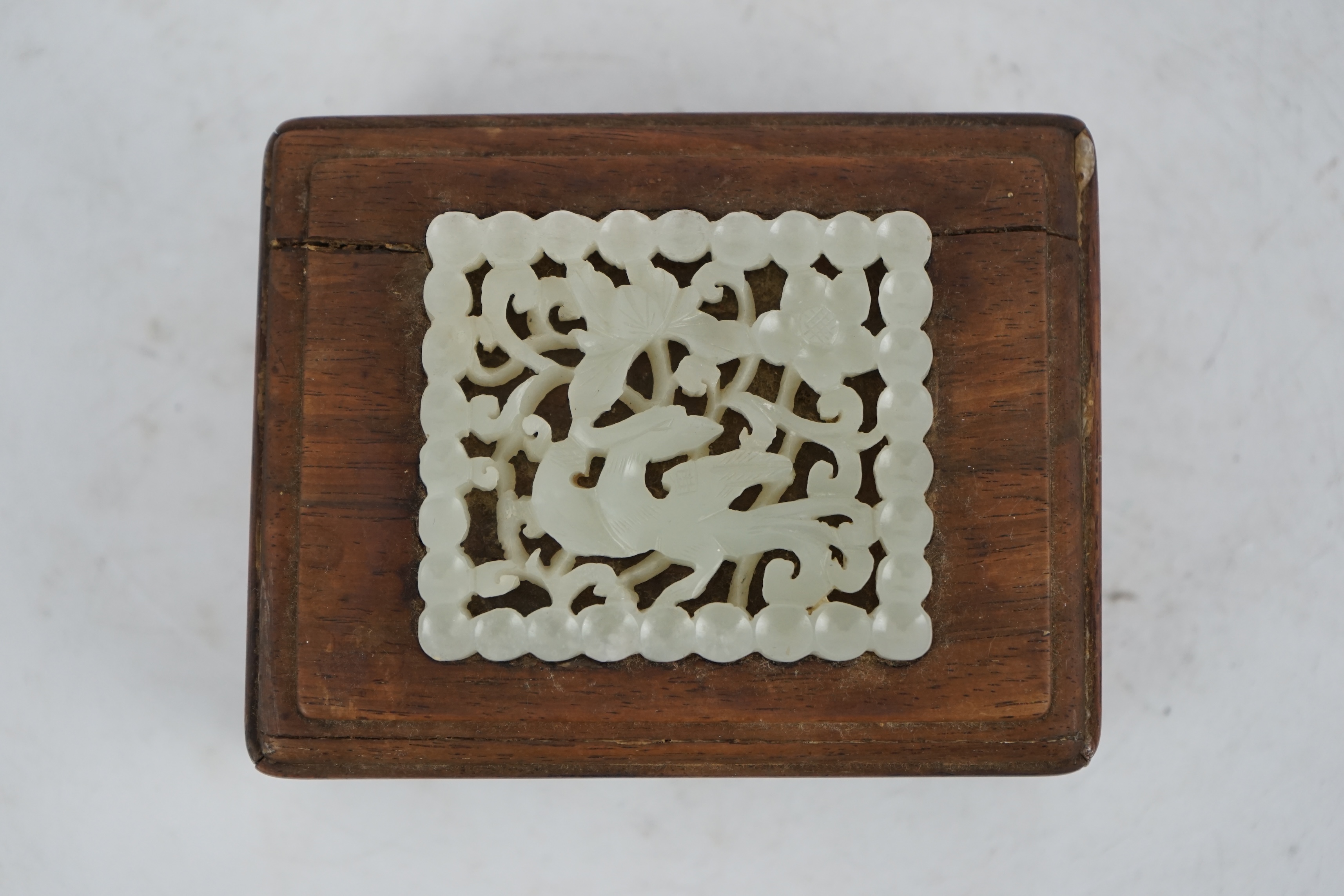 A Chinese pale celadon jade plaque, 17th/18th century, now inset into a hongmu box